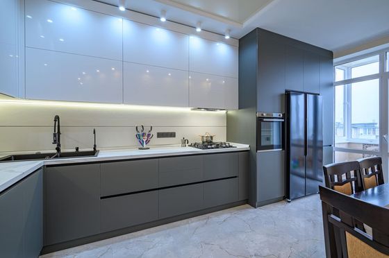 A kitchen with a dining table and chairs and a refrigerator.