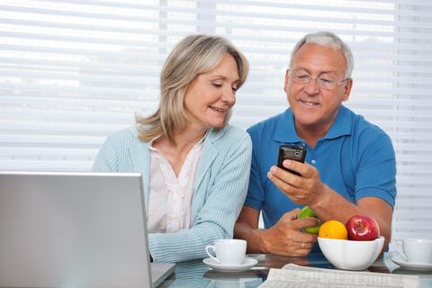 Elderly Couple Checking Text Messages On Phone Exited To Get Special Offer