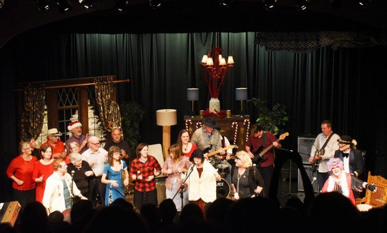 A group of people are standing on a stage in front of a crowd.