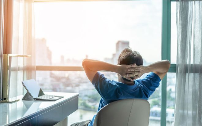 Man leaning back in his seat as sunlight shines in from his open window