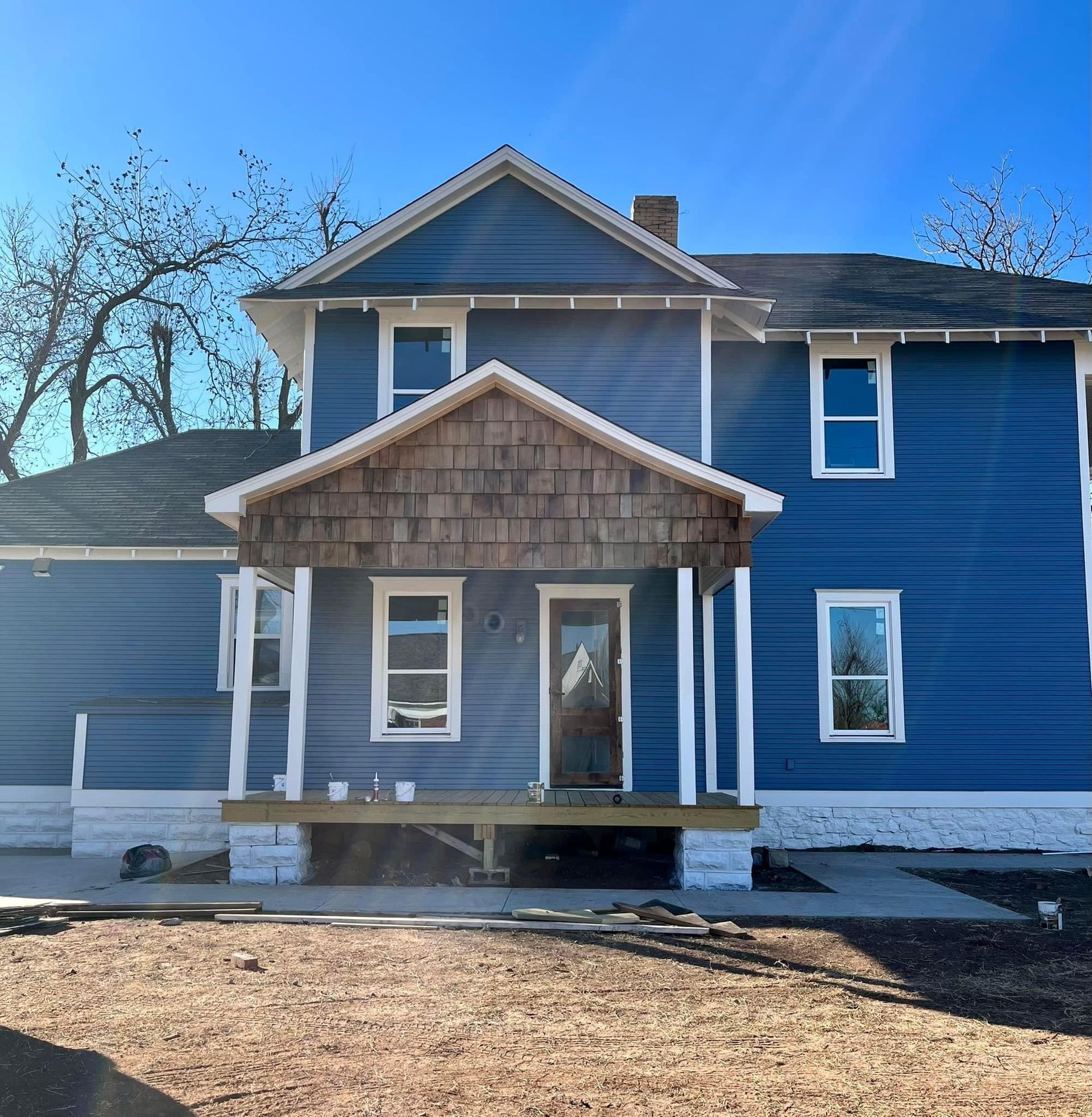 A blue house with white trim and a porch