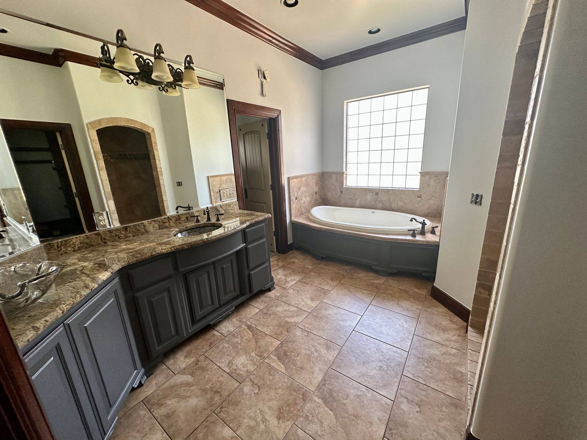 A bathroom with a tub , sink and mirror