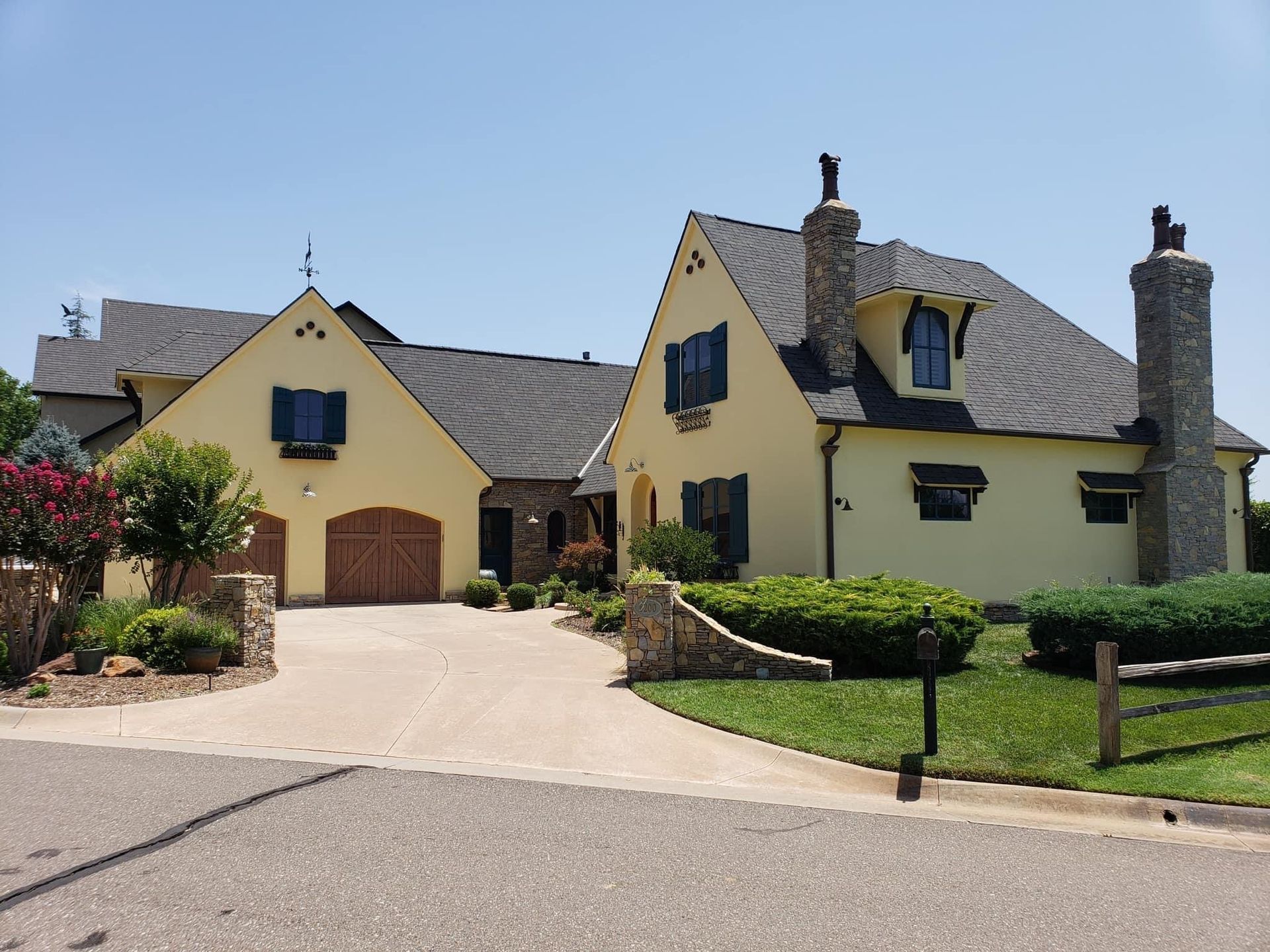 A large yellow house with a driveway leading to it