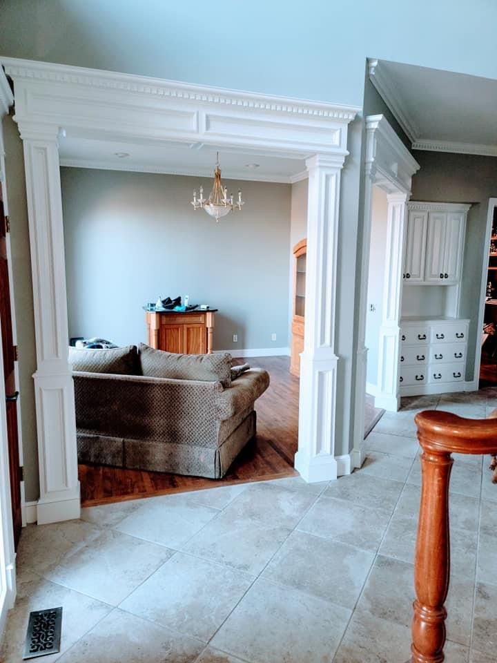 A living room with a couch and stairs leading to the dining room.