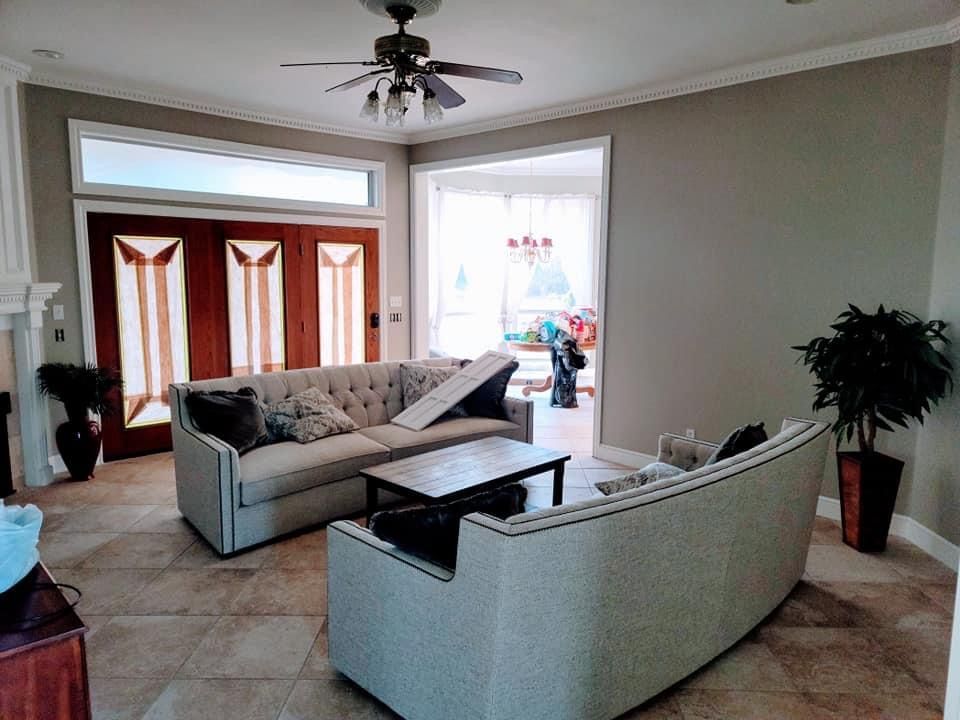 A living room with two couches , a coffee table and a ceiling fan.
