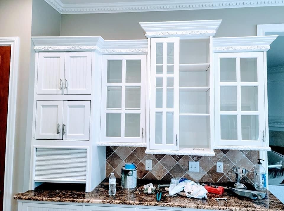 A kitchen with white cabinets and a granite counter top.