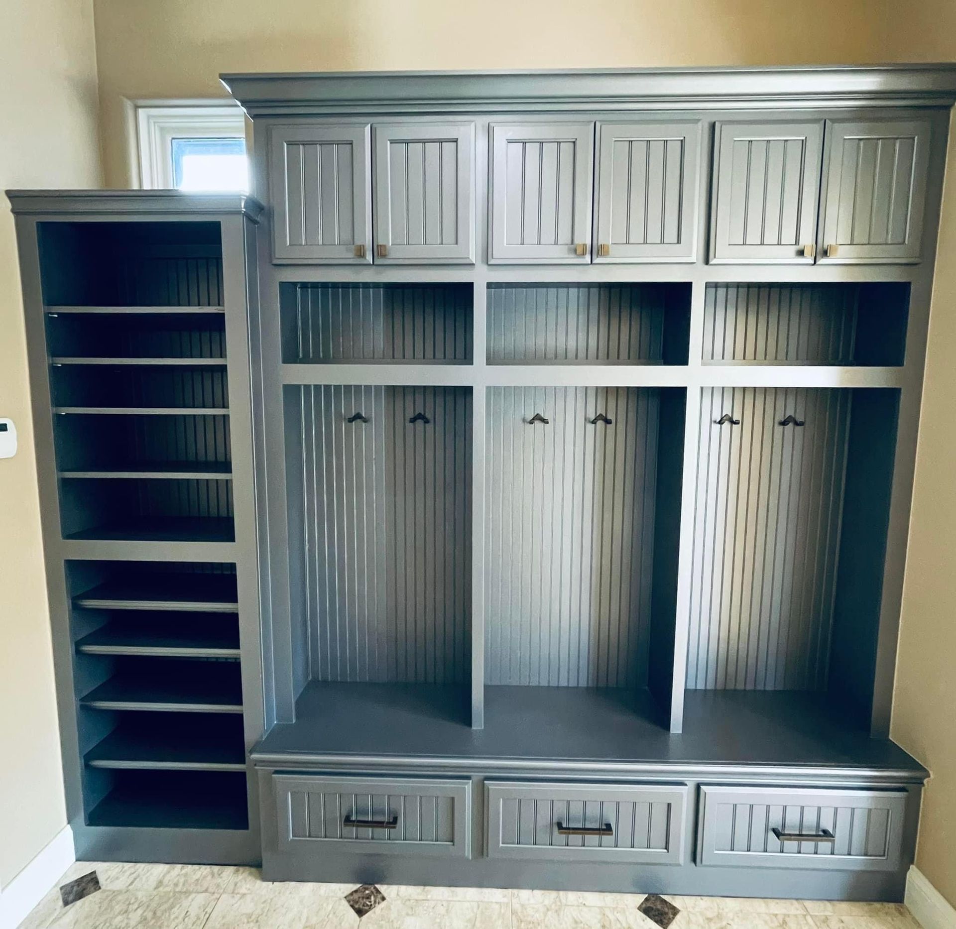 A large gray cabinet with lots of shelves and drawers