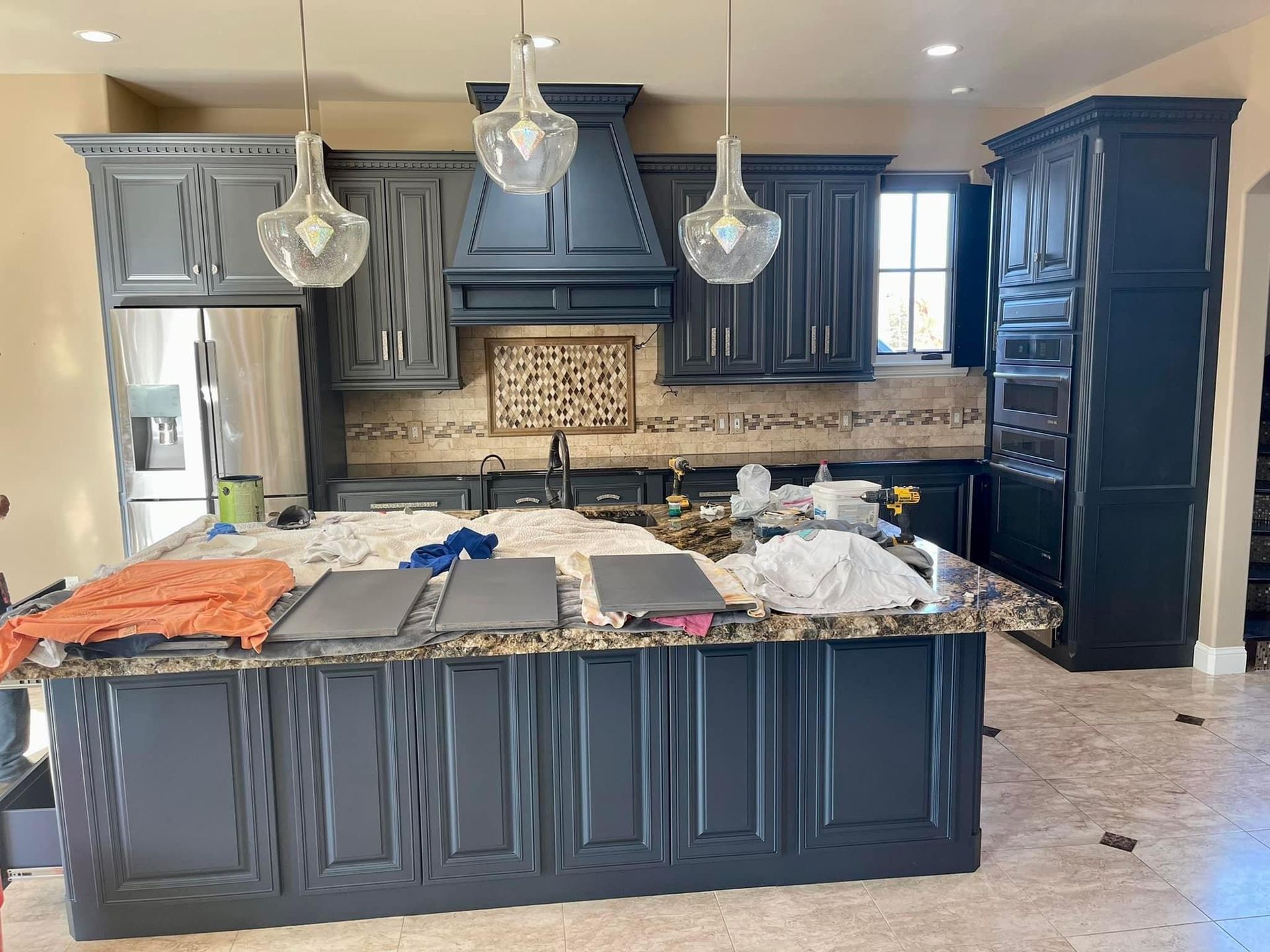 A kitchen with black cabinets and granite counter tops is being remodeled.