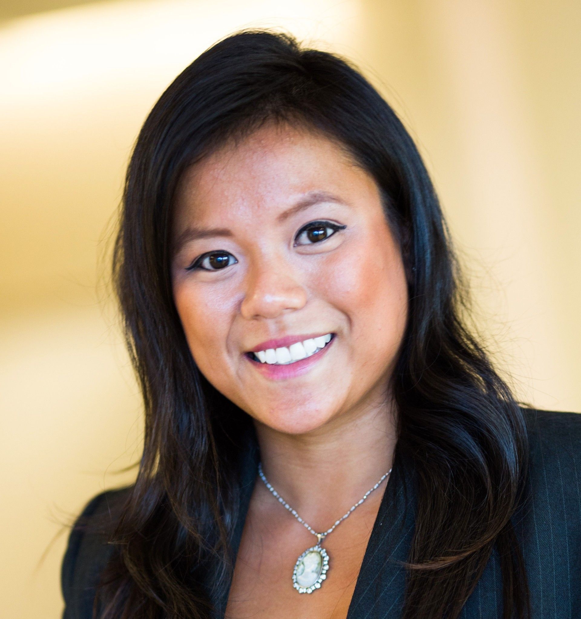Group of people posing by a painted bear statue outside a building.