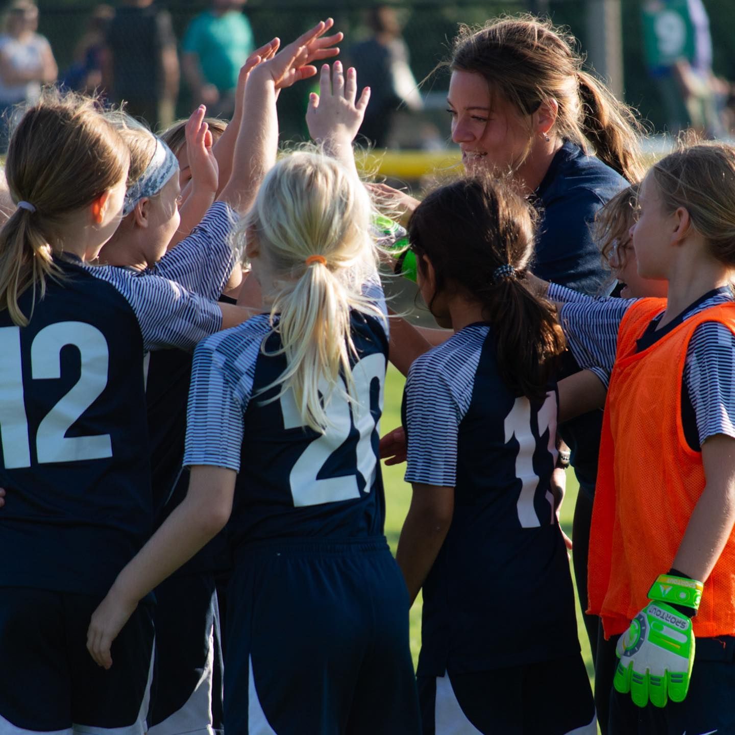 A group of girls wearing jerseys with the number 12 on them