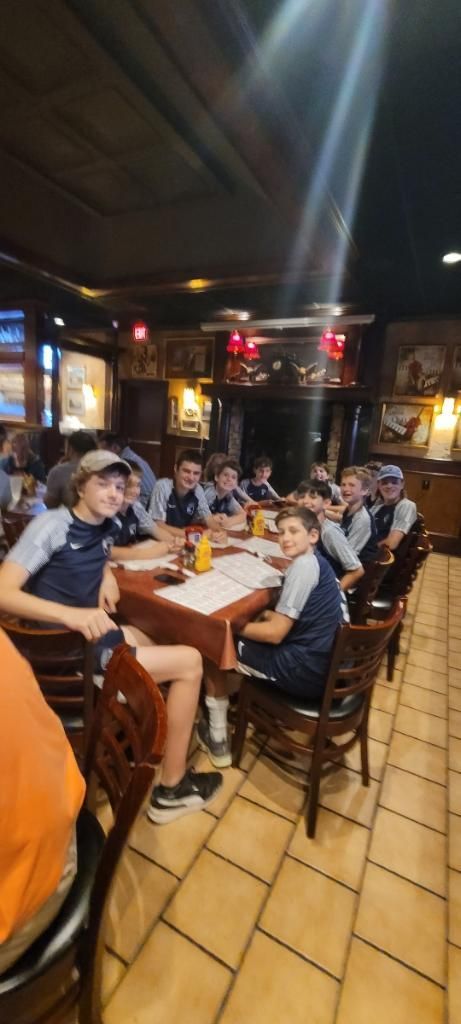 A group of people are sitting at tables in a restaurant.