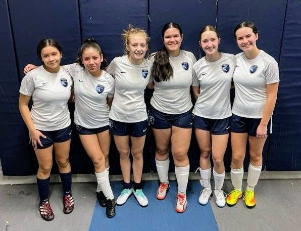 A group of girls are posing for a picture together.