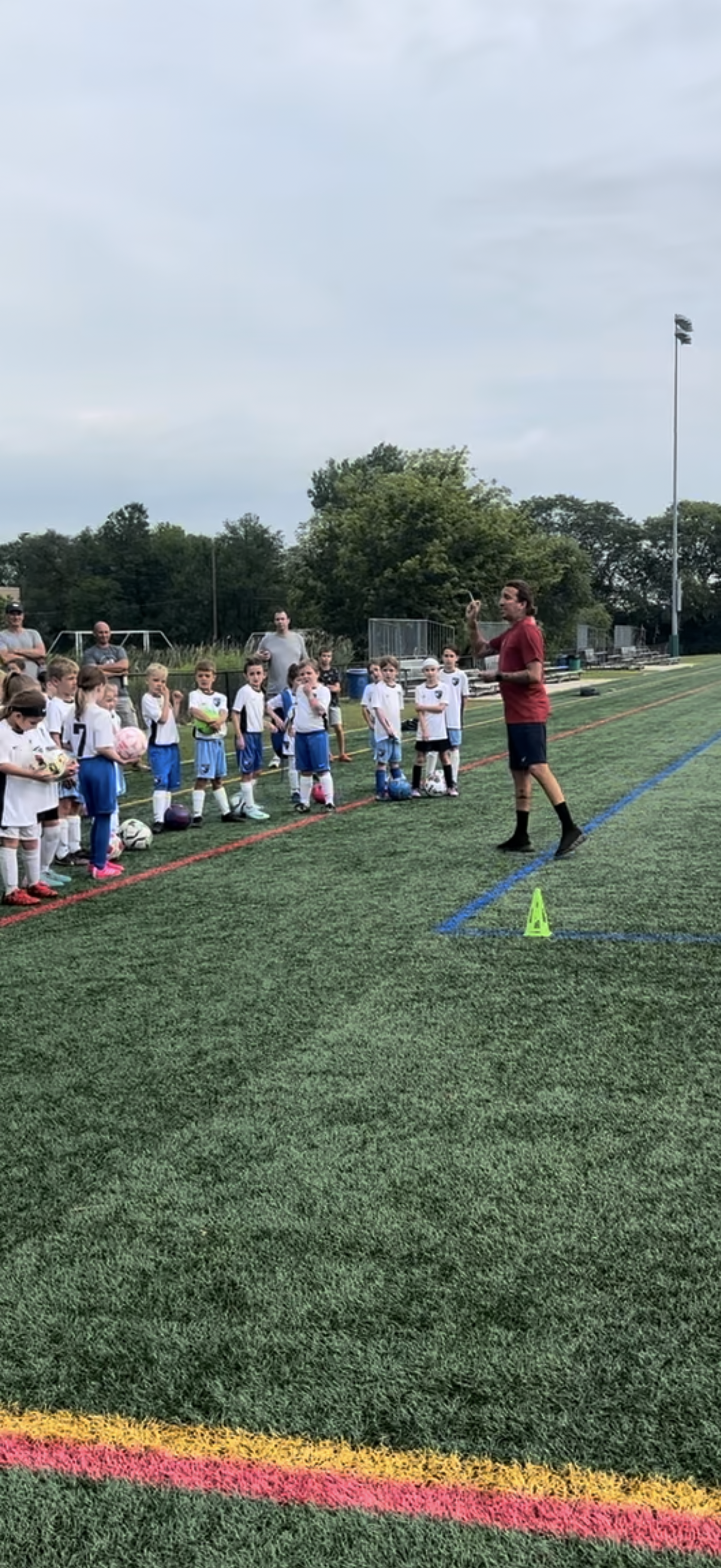 A group of children are playing soccer on a field.