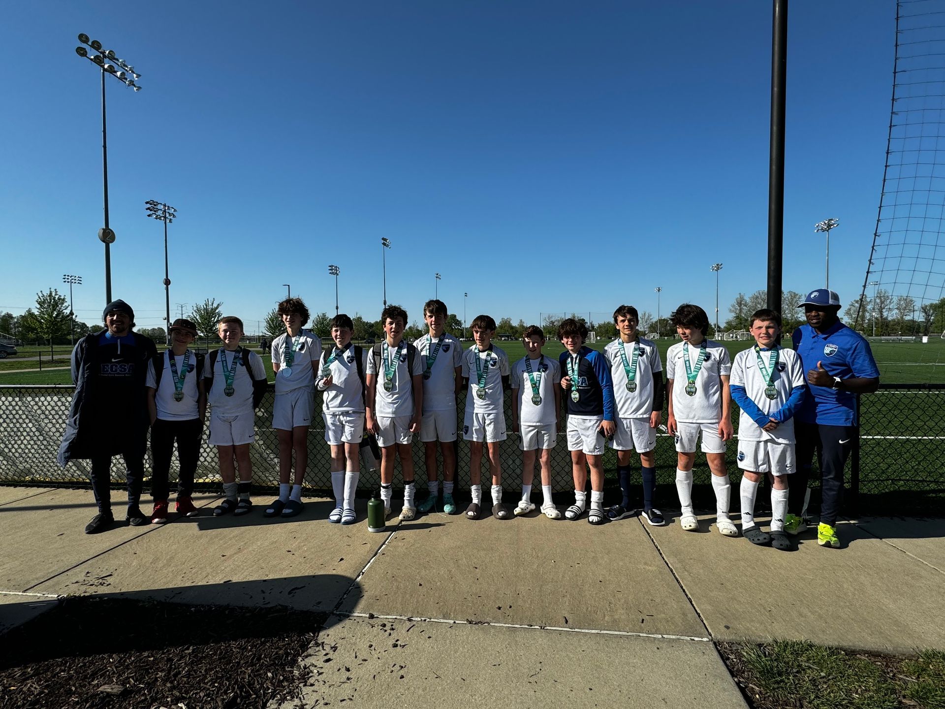 A group of young boys are posing for a picture on a sidewalk.