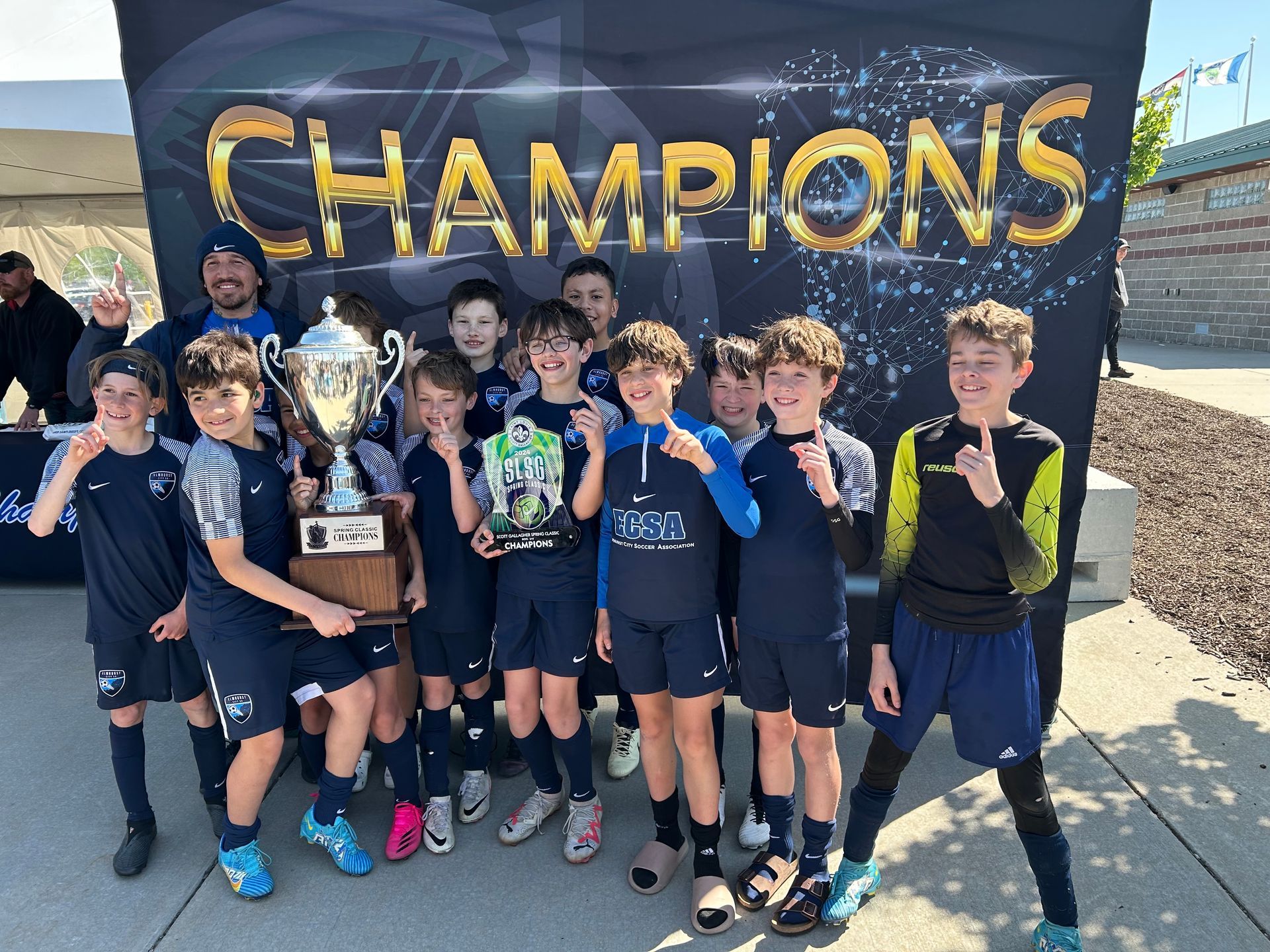 A group of young boys standing in front of a banner that says champions