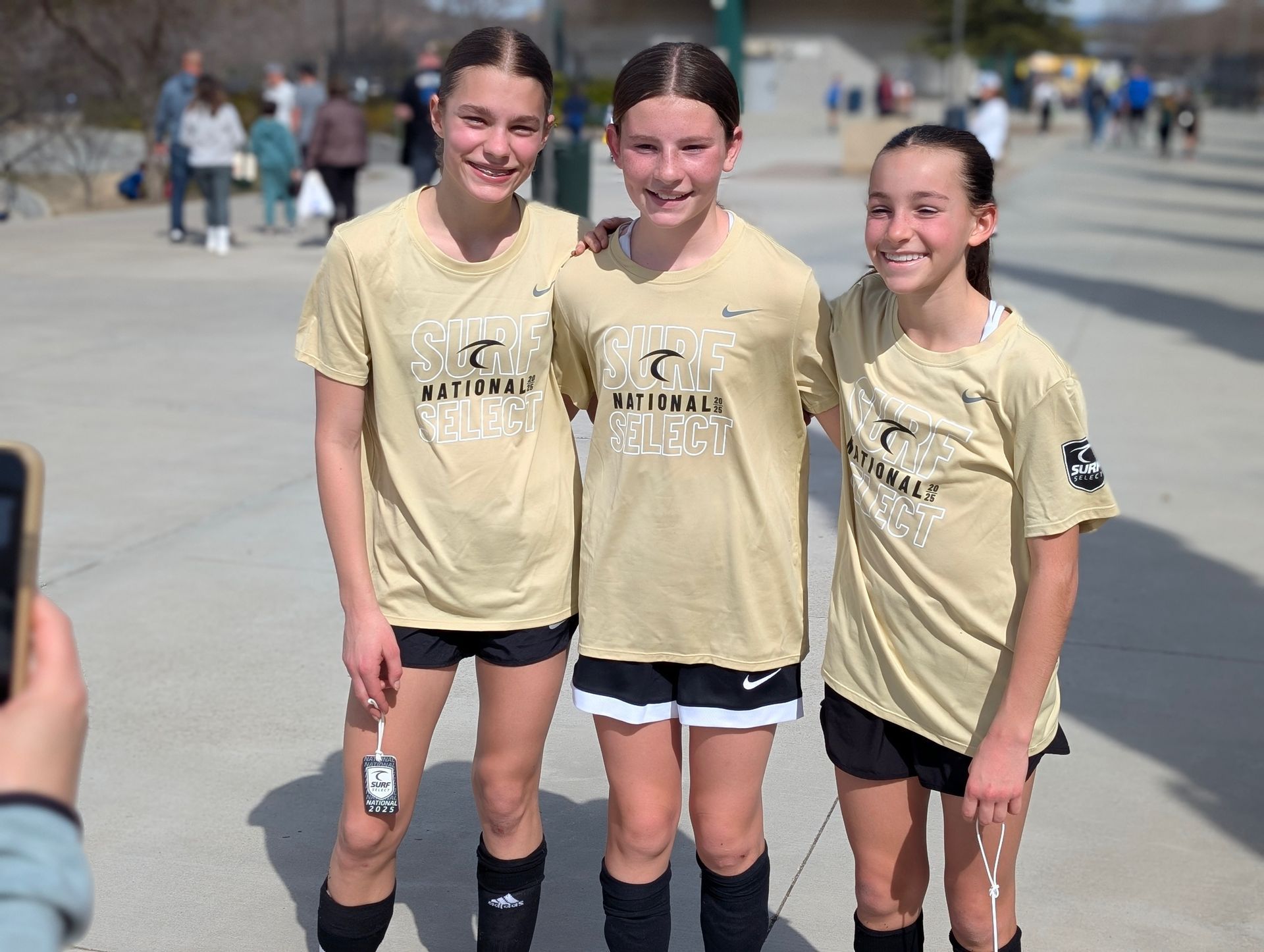 Three young girls are posing for a picture together.