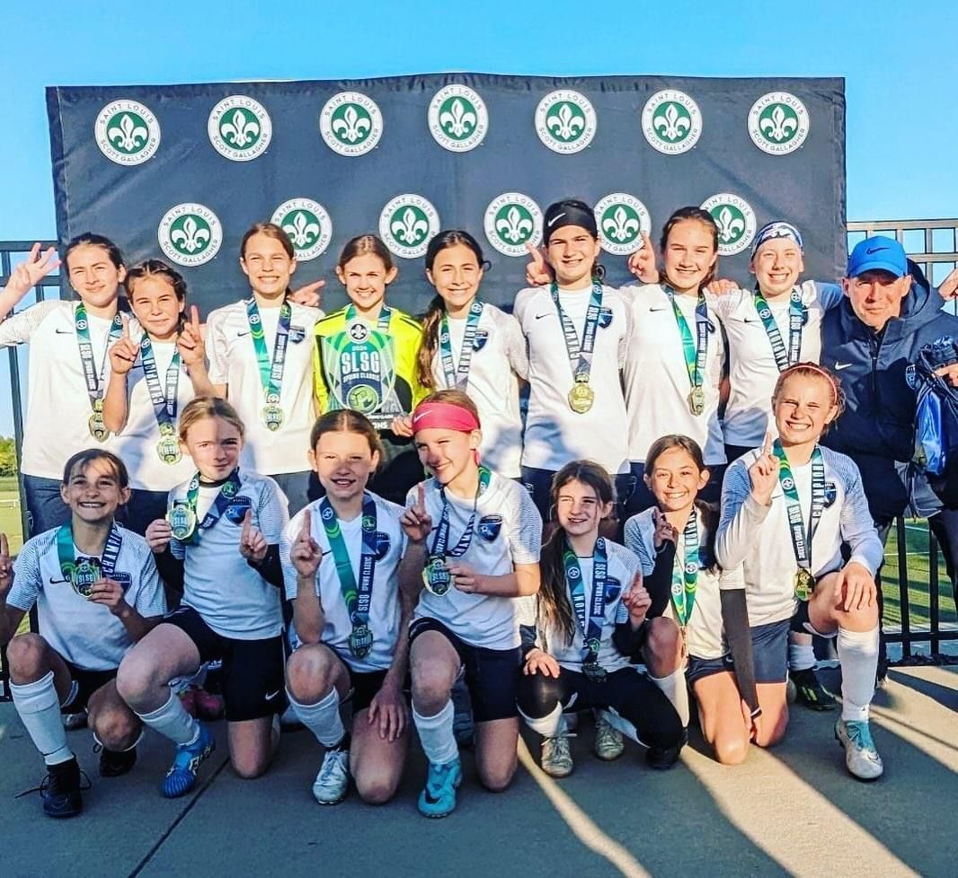 A group of young girls are posing for a picture while wearing medals.