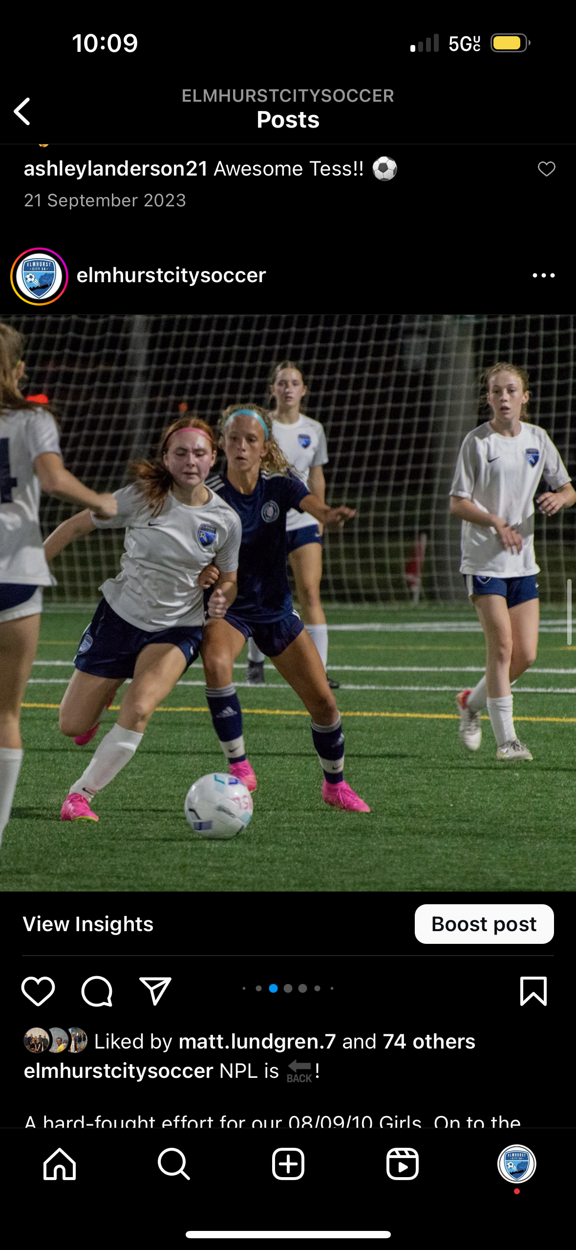 A group of young girls are playing soccer on a field.