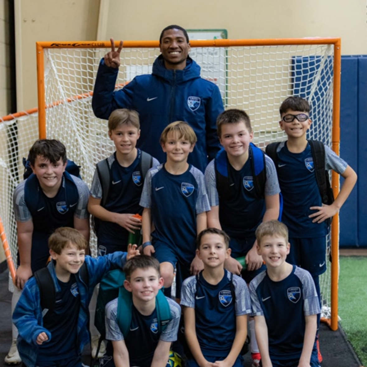 A group of young boys posing for a picture in front of a goal