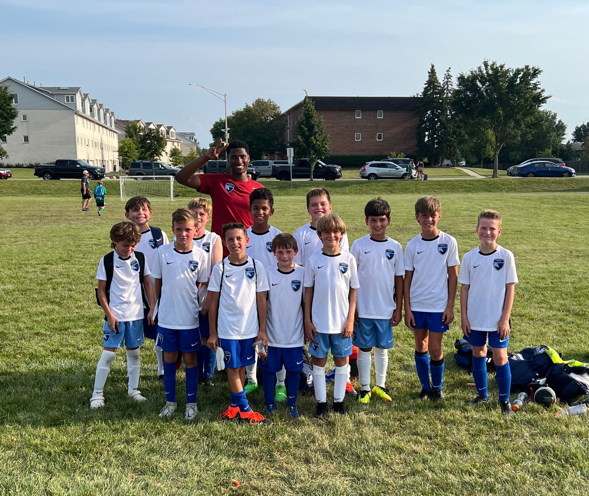 A group of young boys are posing for a picture on a soccer field.