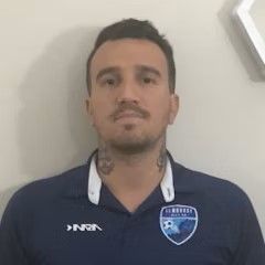 A man with a tattoo on his neck is wearing a blue shirt.