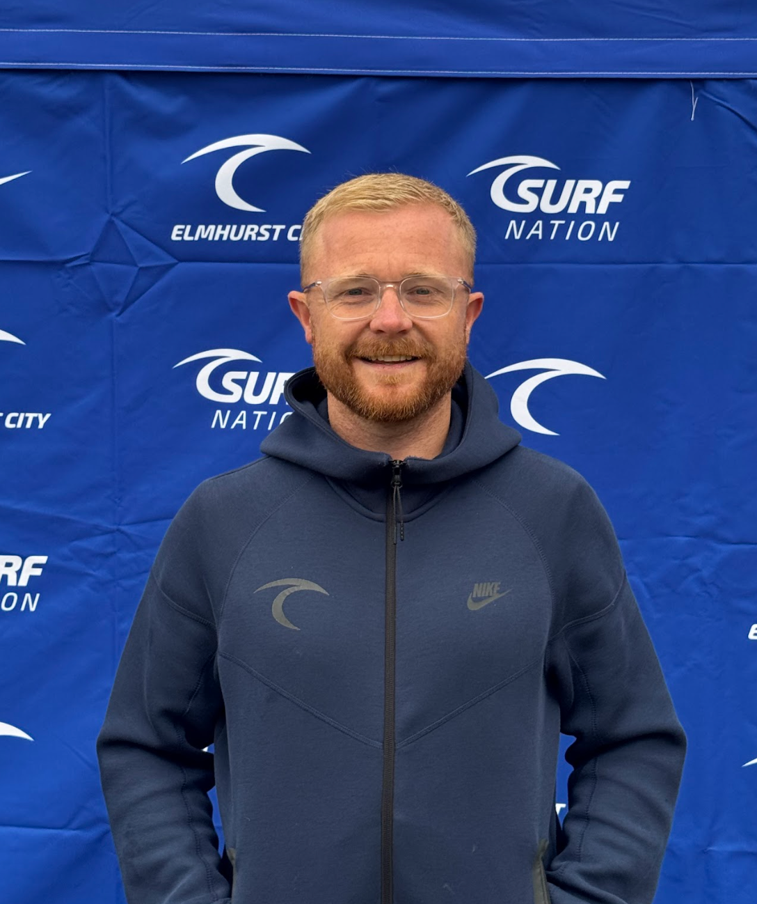 A man is holding a trophy in a car and smiling.