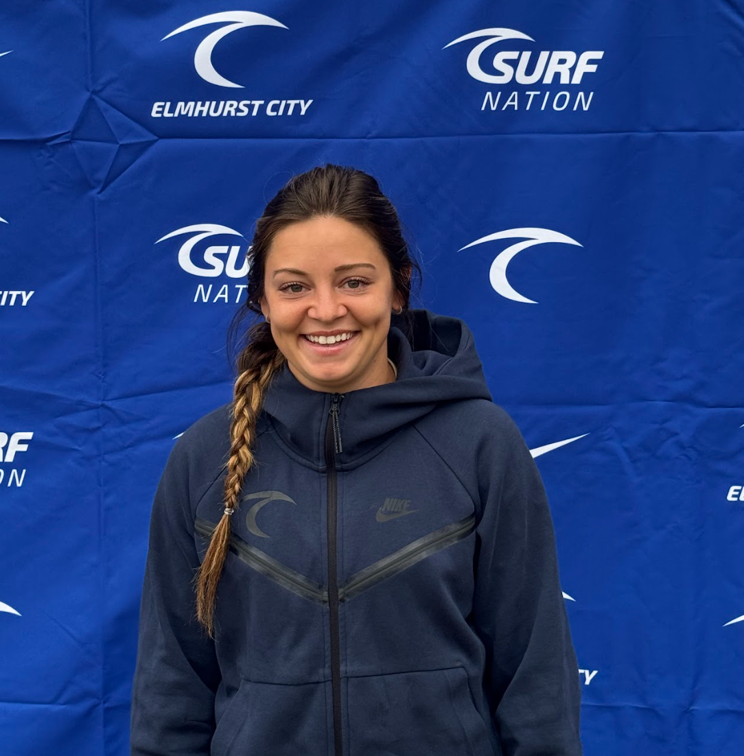 A woman in a white shirt with the number 9 on it is holding a soccer ball.