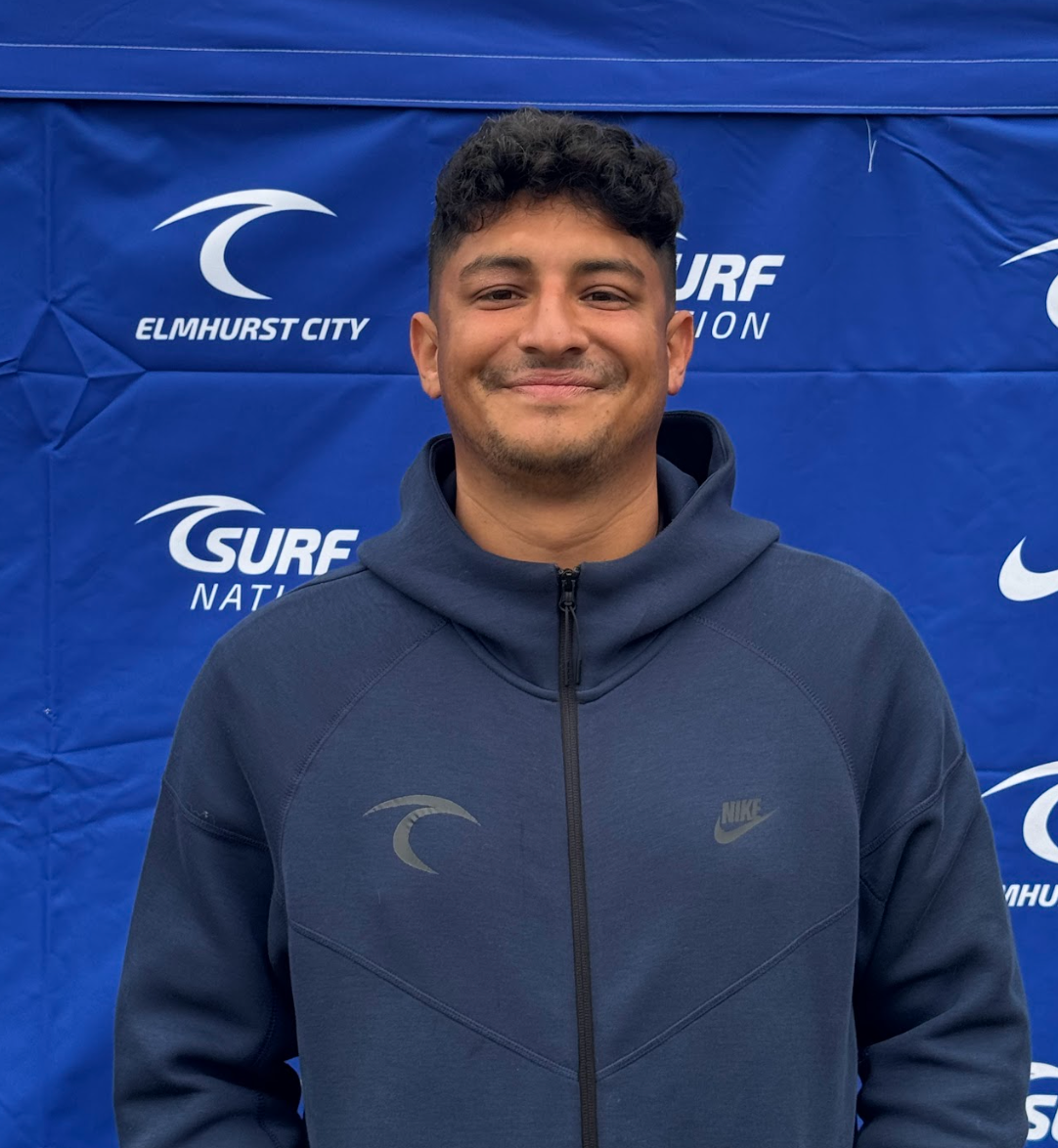 A young man is holding a trophy on a soccer field.