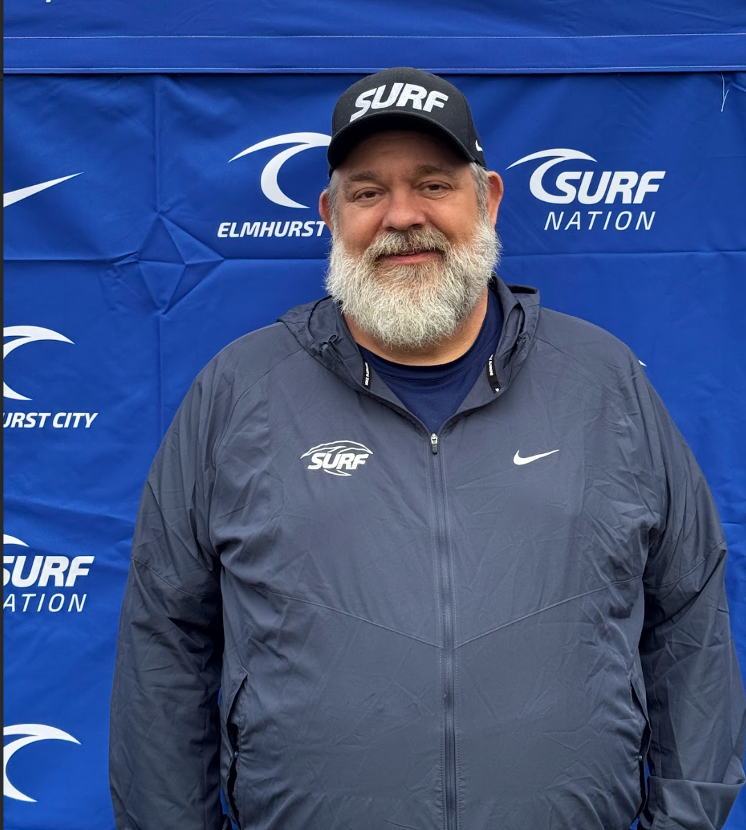 A man with a beard is wearing a suit and tie.