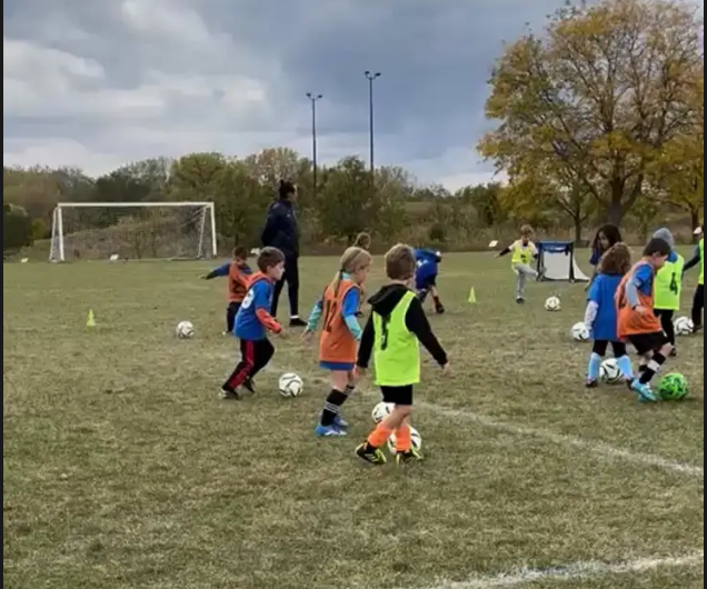 A group of children are playing soccer on a field