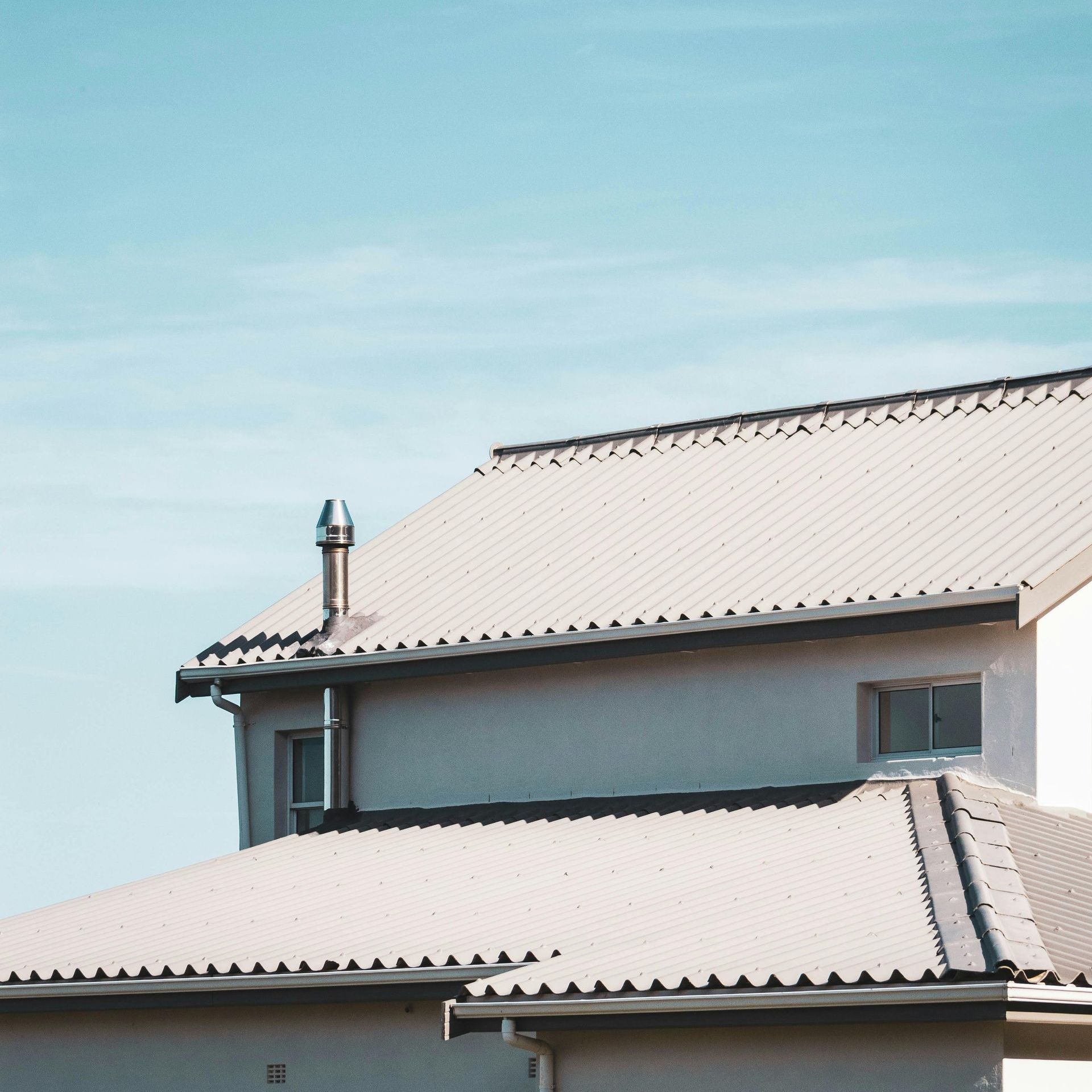 A house with a roof that has a chimney on it