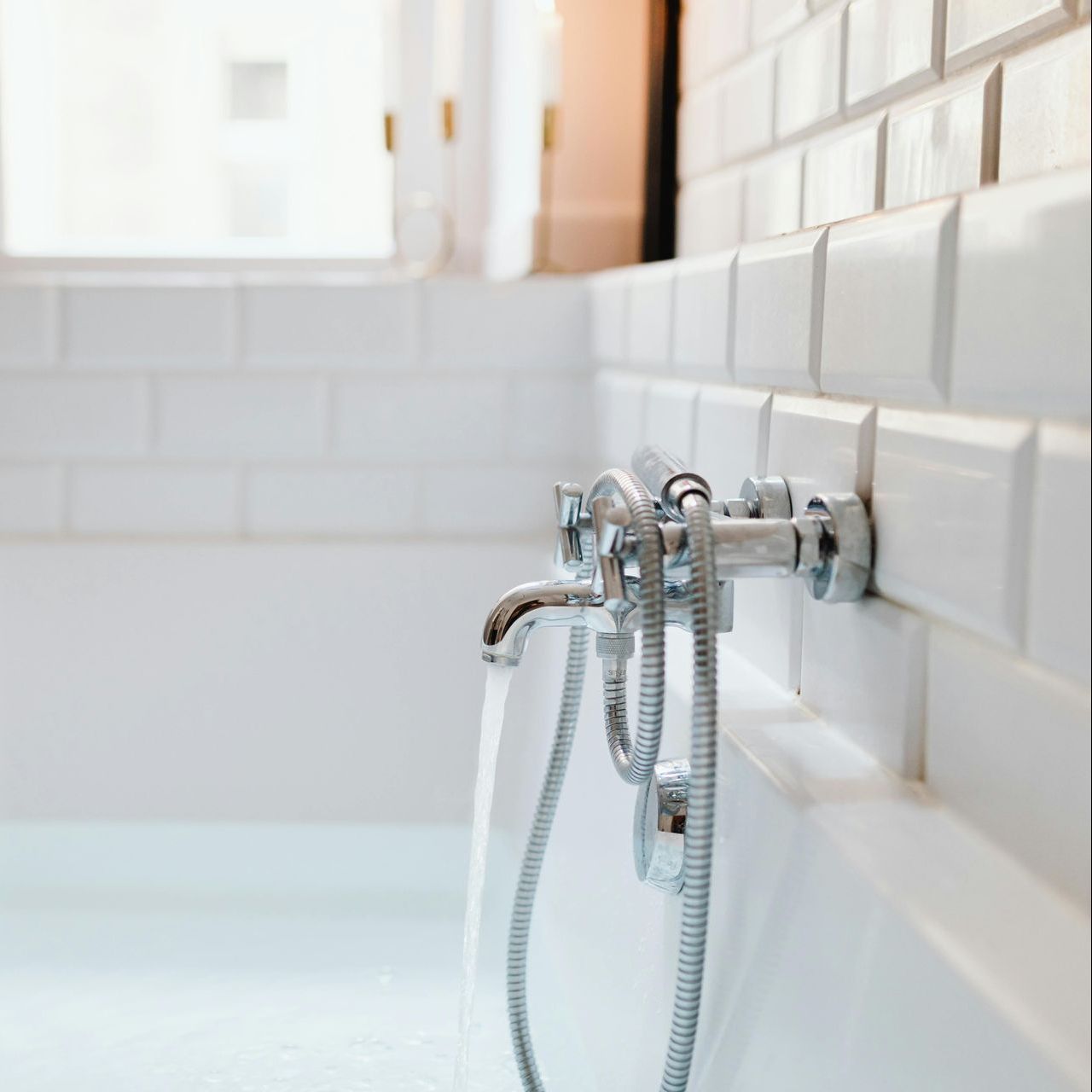 A close up of a bathtub with a shower head attached to it.