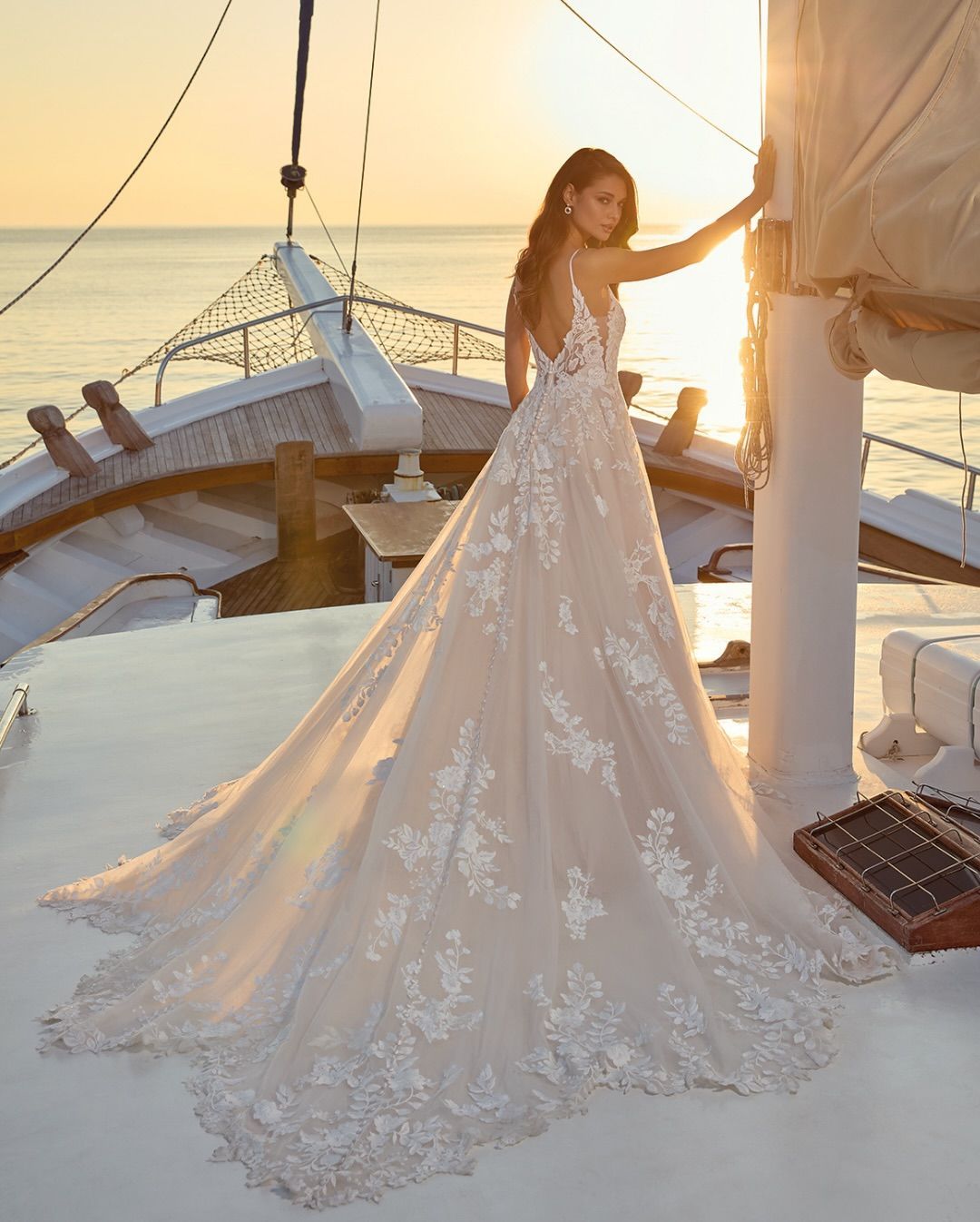 A woman in a white wedding dress is standing in a room surrounded by flowers.
