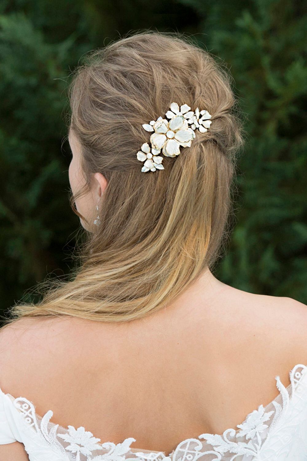 The back of a woman wearing a wedding dress and a hair clip.