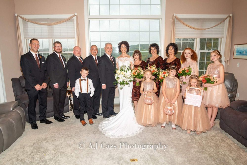 The bride and groom are posing for a picture with their wedding party.