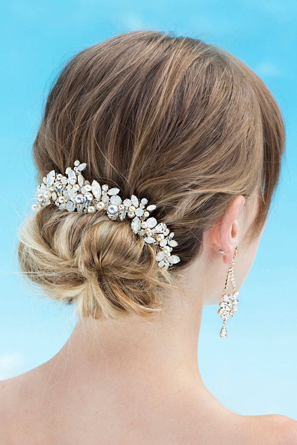 A woman is wearing a bun with a comb in her hair.