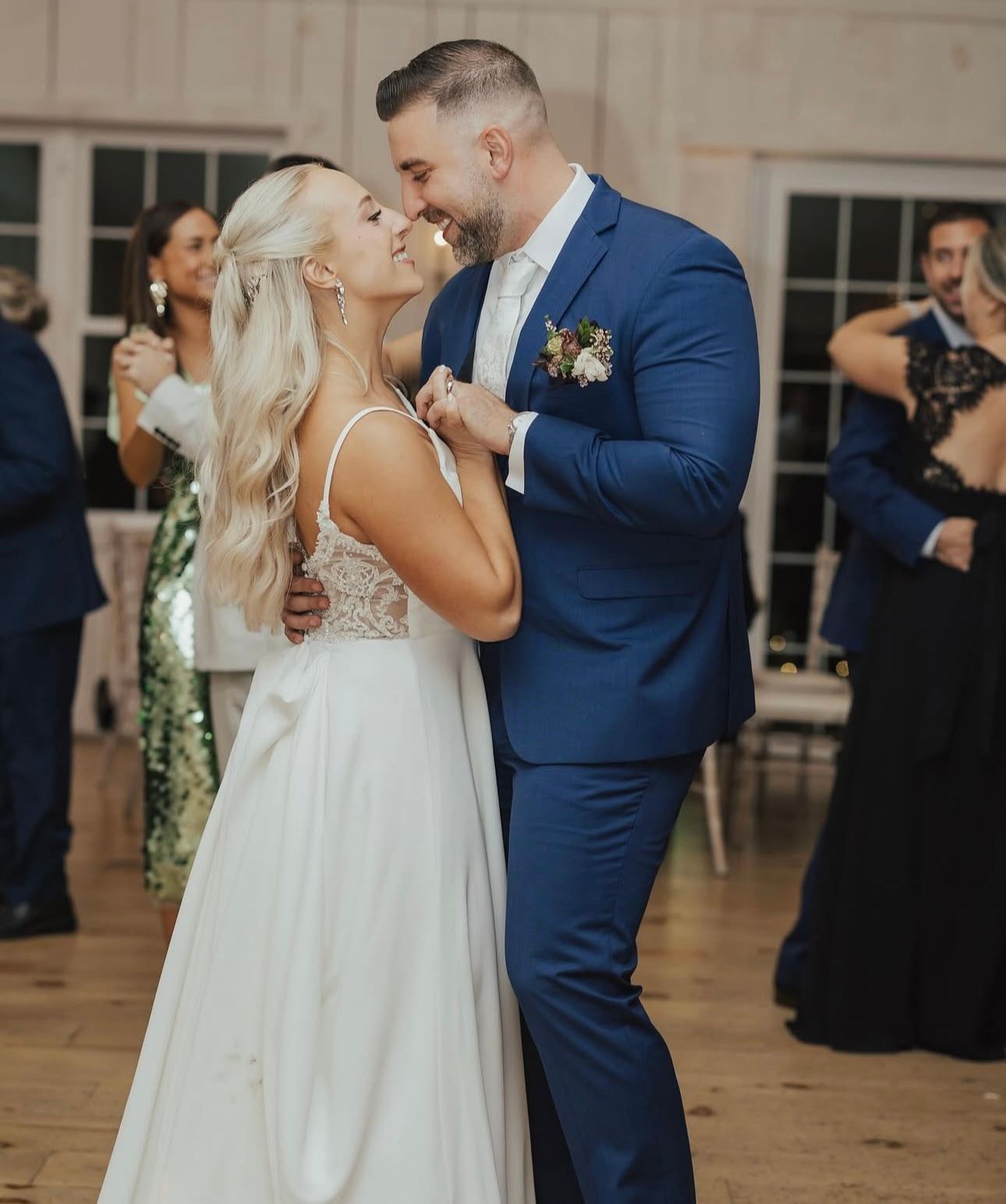 A bride and groom are dancing together at their wedding reception