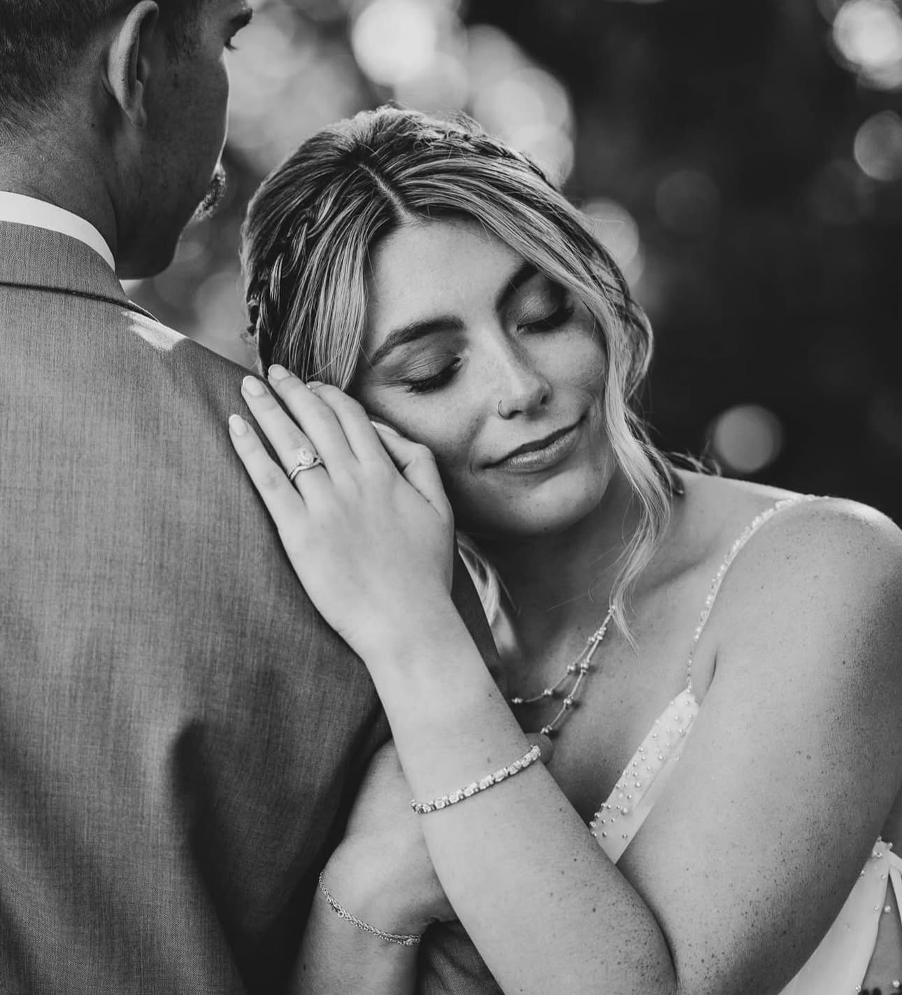 A black and white photo of a bride and groom hugging