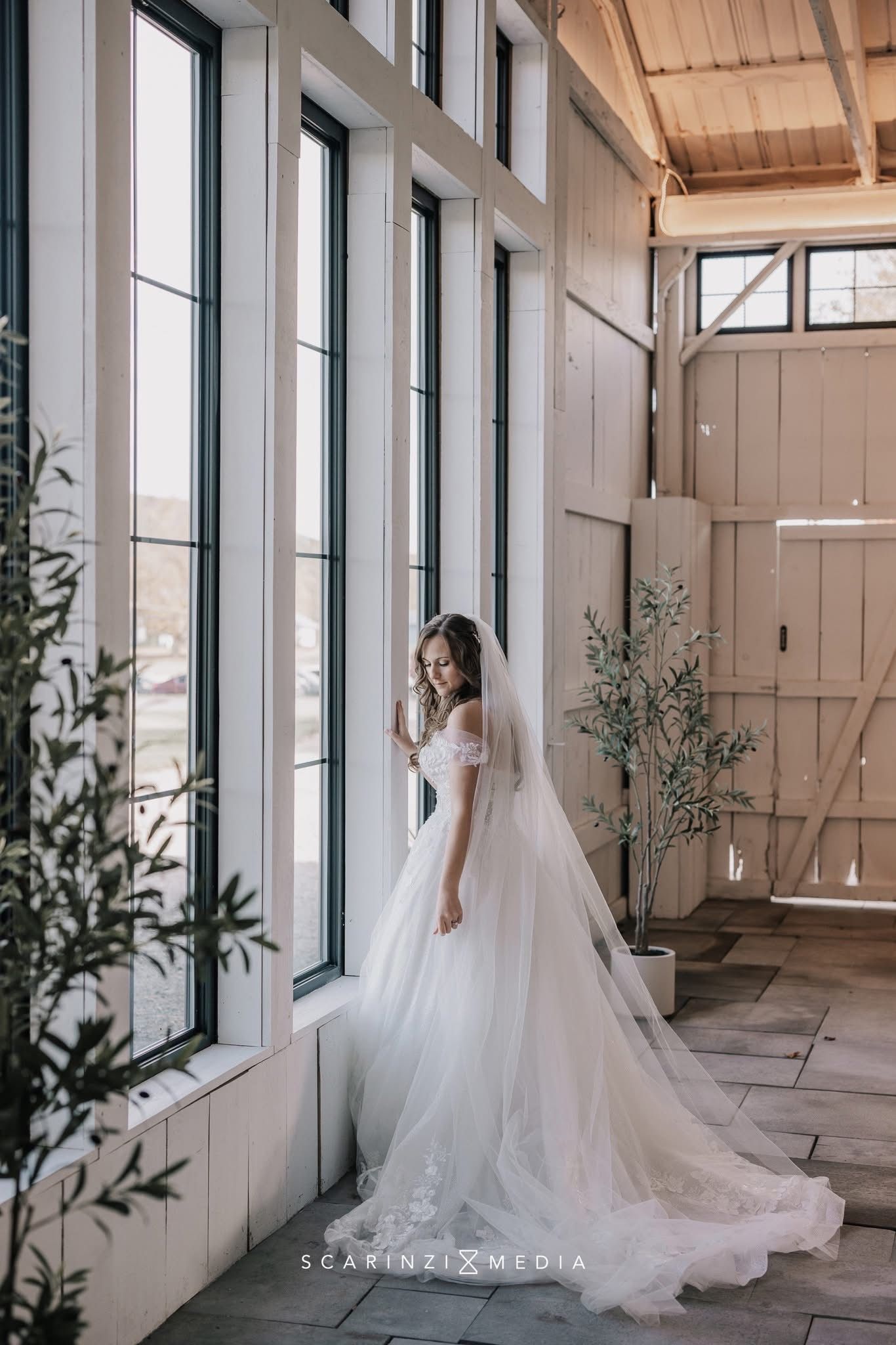 A woman in a white wedding dress is standing in front of a mountain.