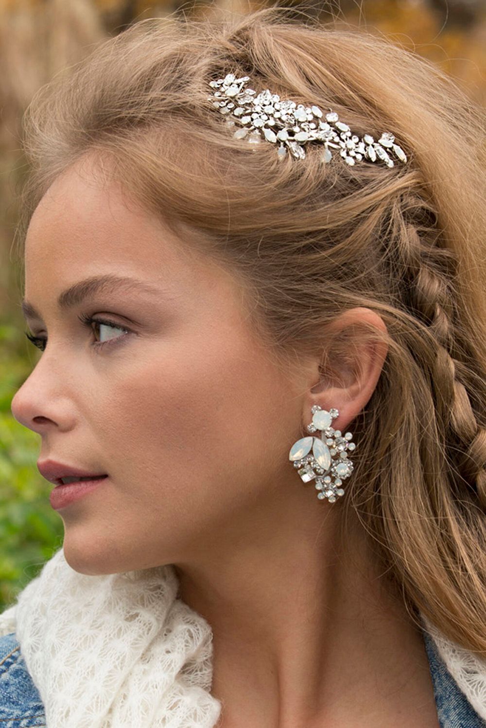 A woman is wearing a headpiece and earrings.