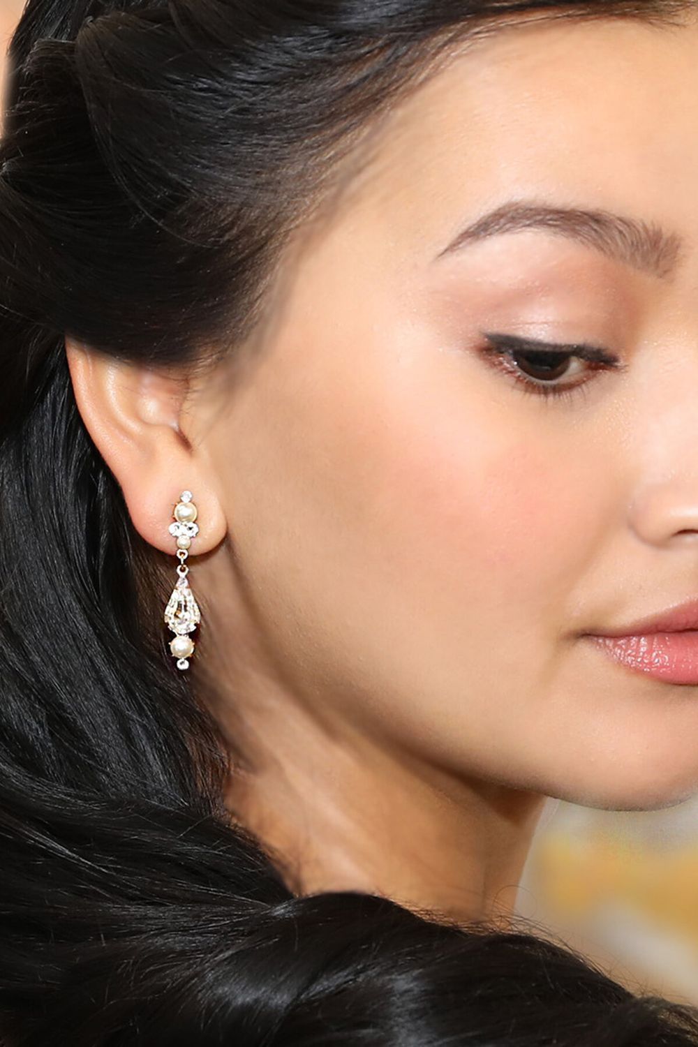 A close up of a woman wearing earrings on her left ear