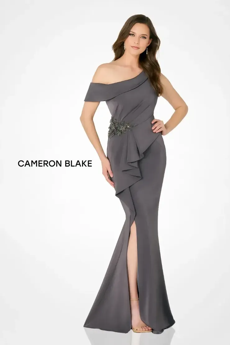 A woman is wearing a gray off the shoulder dress by cameron blake