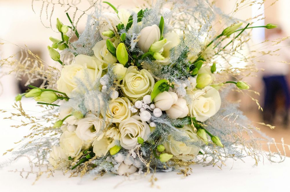 A close up of a bouquet of white flowers on a table.