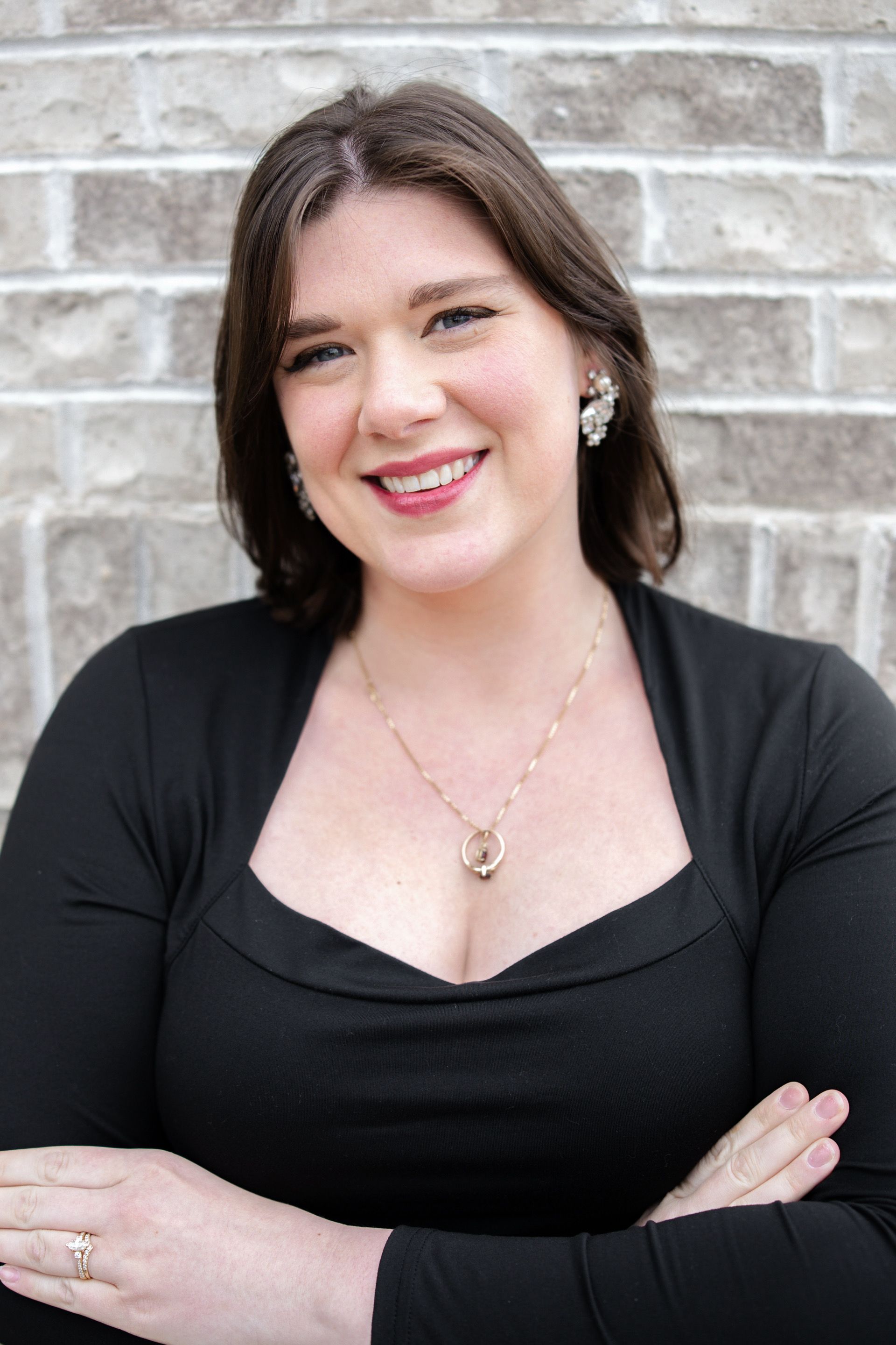 A woman is smiling while talking on a cell phone.