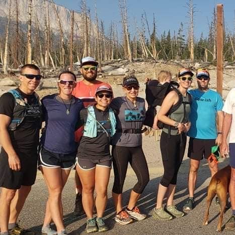 A group of people posing for a picture with a dog.