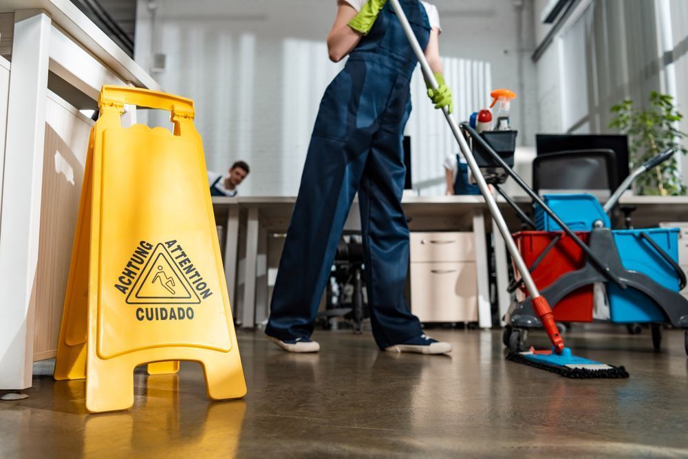 A Person is Mopping the Floor in an Office — O & D House Wash & Cleaning Services in Cambooya, QLD