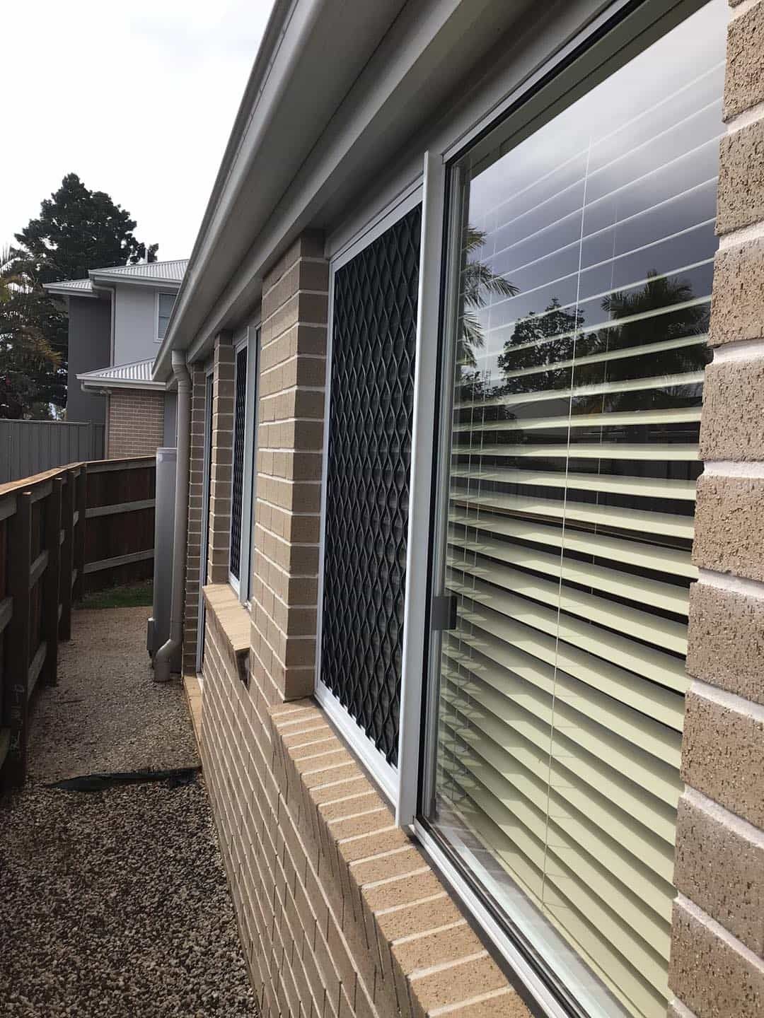 A brick building with a lot of windows and blinds on it. — O & D House Wash & Cleaning Services in Oakey, QLD