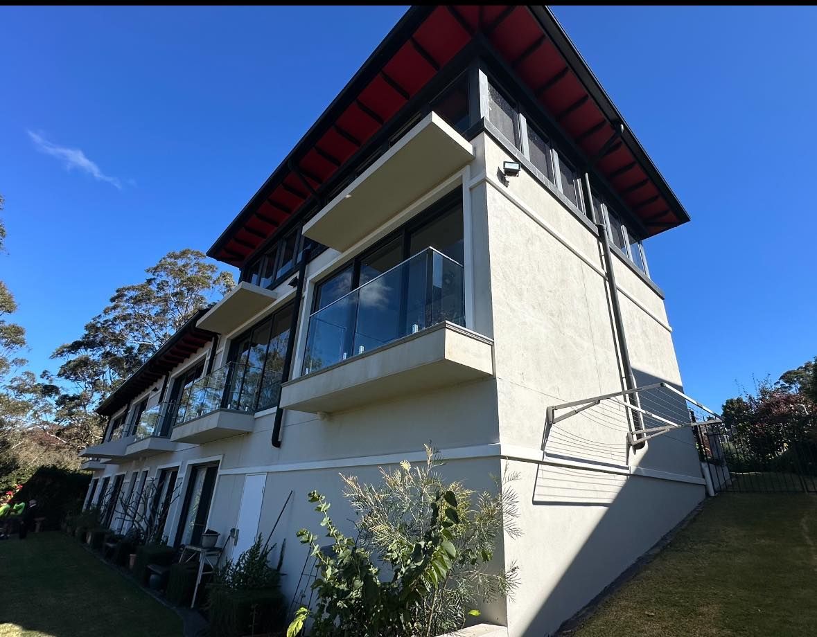 A Large White House With a Red Roof and Balconies — O & D House Wash & Cleaning Services in Westbrook, QLD
