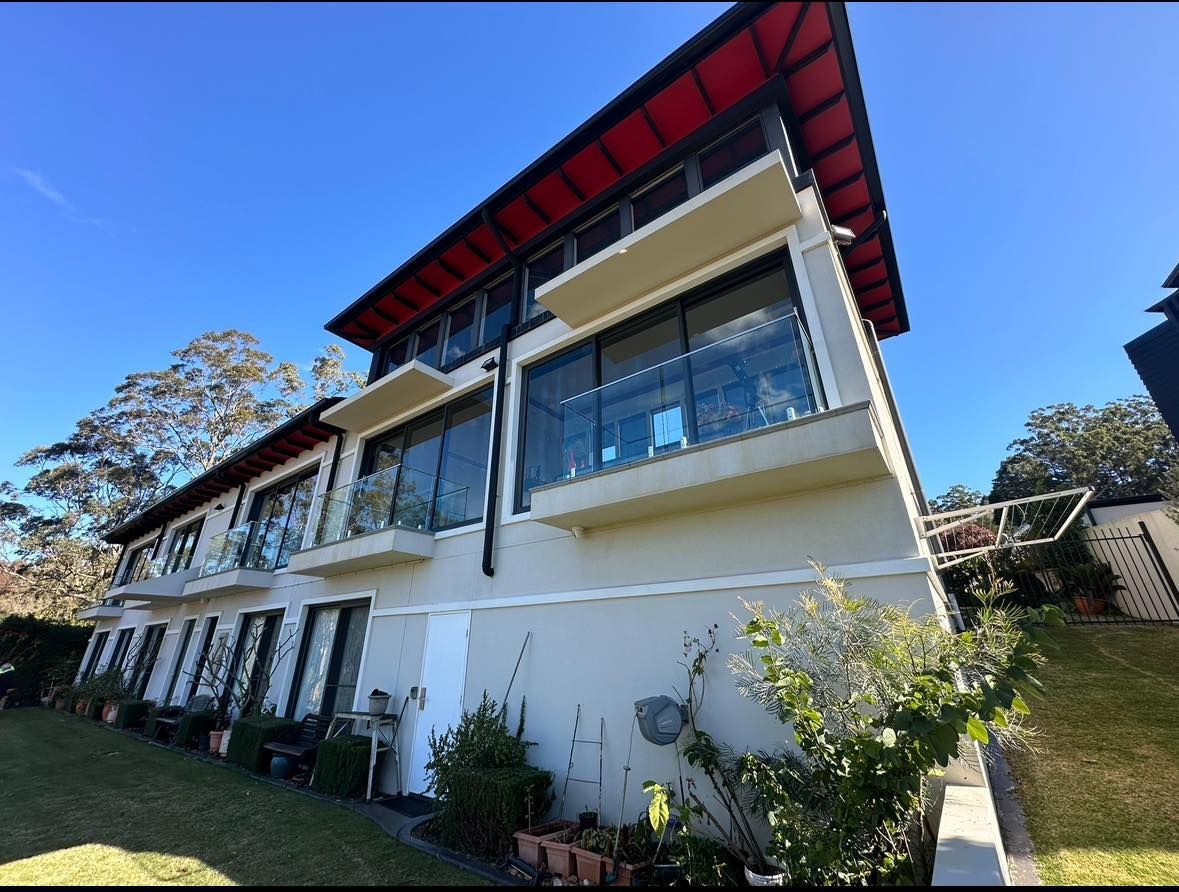 A Large White Building With a Red Roof — O & D House Wash & Cleaning Services in Highfields, QLD
