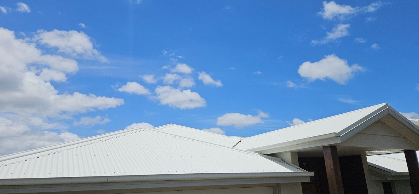 A House With a White Roof and a Blue Sky With Clouds — O & D House Wash & Cleaning Services in Highfields, QLD
